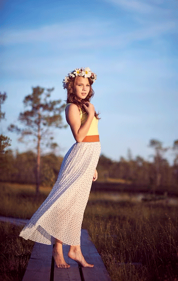 adolescente-atractiva-vestida-falda-larga-guirnalda-cabeza-posando-campo-al-amanecer_61391ff0-10715